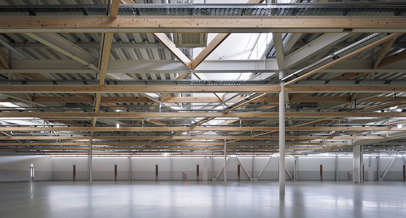 工場棟内部　木製の生産設備ラックはぶどう棚をイメージ。屋根と生産設備を幾何学的に関連性を持たせて、旭陽電気の祖業であるハーネス（電線）の「繋ぐ」イメージを体現